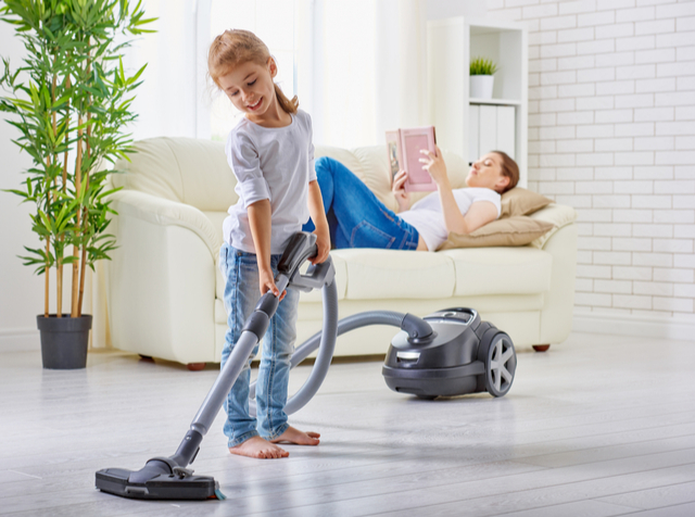 Child vacuuming the floor